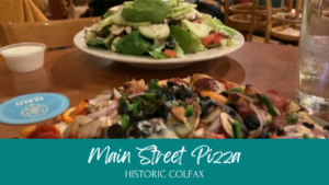 A cozy interior of Main Street Pizza in Colfax, CA, featuring freshly baked pizzas on display.